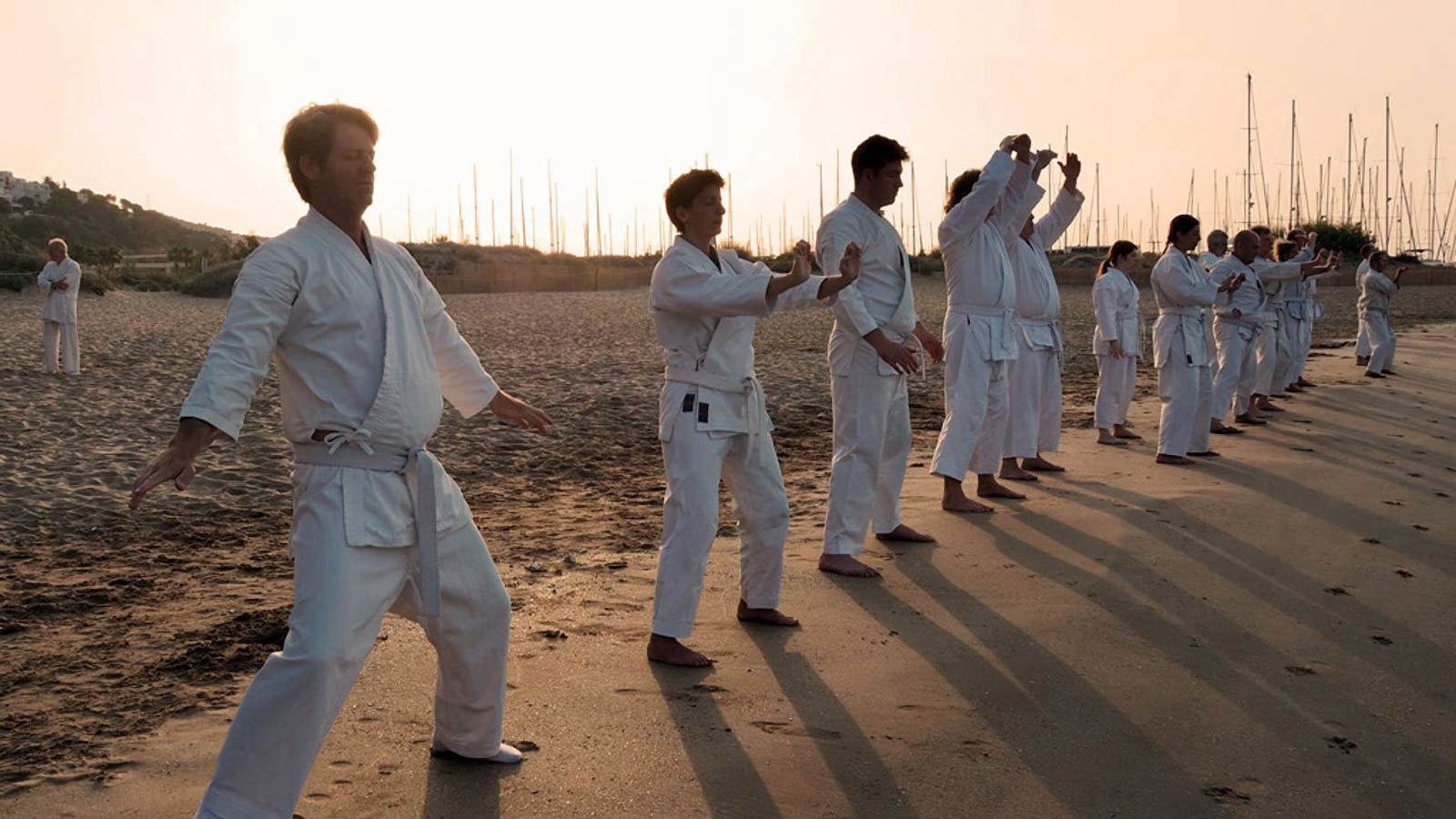 Alumnos en formación en la playa al atardecer, Karate-Do Gali Peeters Eixample Barcelona
